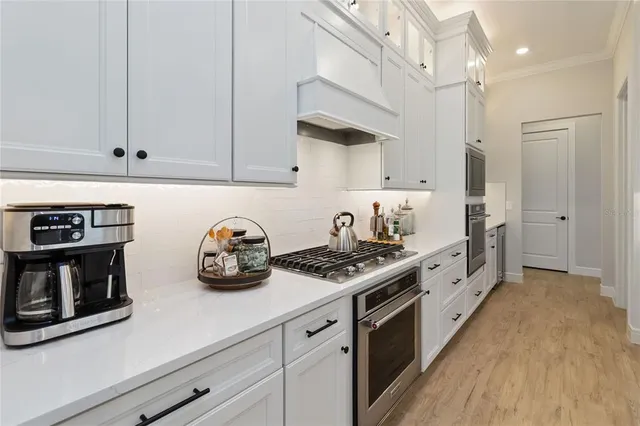 a kitchen with cabinets and steel appliances