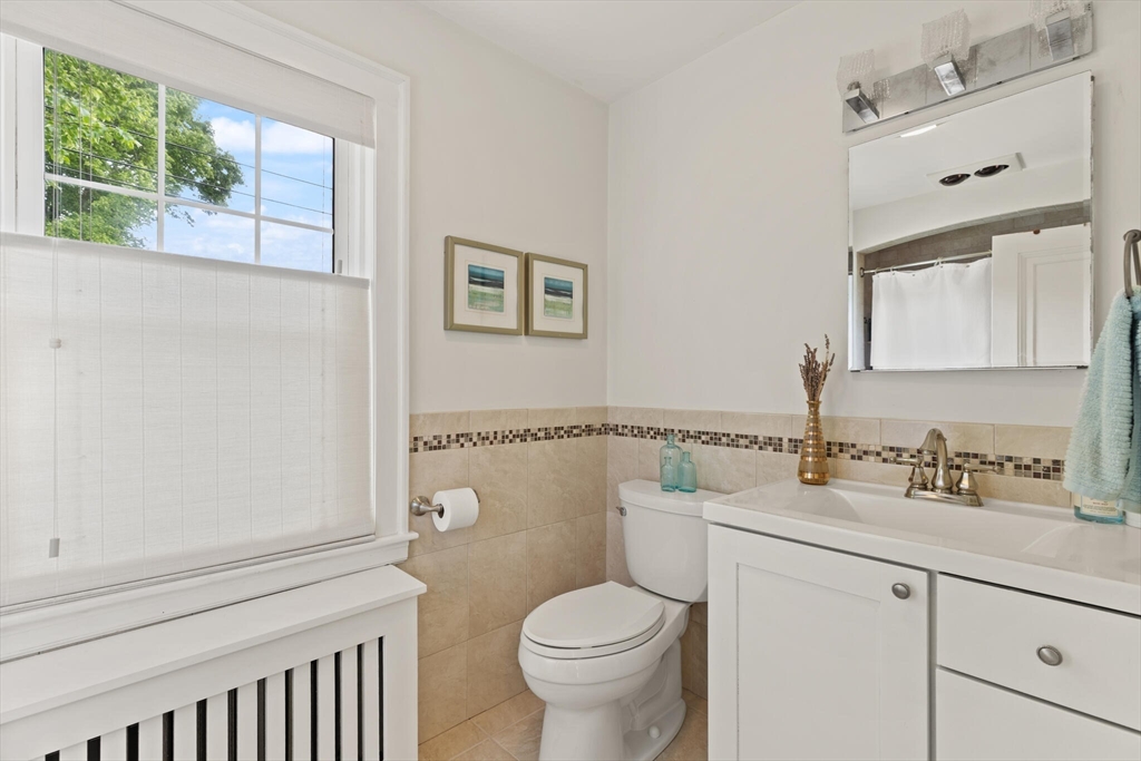61 Howitt Road Boston, MA 02132 - Photo 27 of 42 a bathroom with a granite countertop toilet sink and mirror