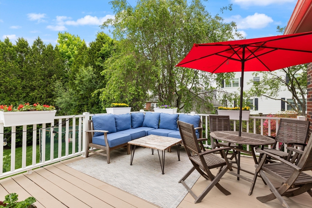 61 Howitt Road Boston, MA 02132 - Photo 32 of 42 a patio with wooden floor a yard a table and chairs