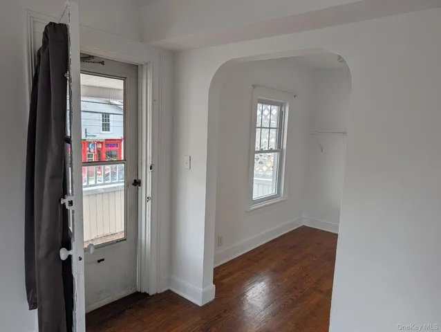 a view of a hallway with wooden floor and closet