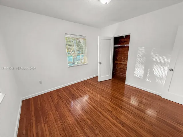 an empty room with wooden floor and fireplace