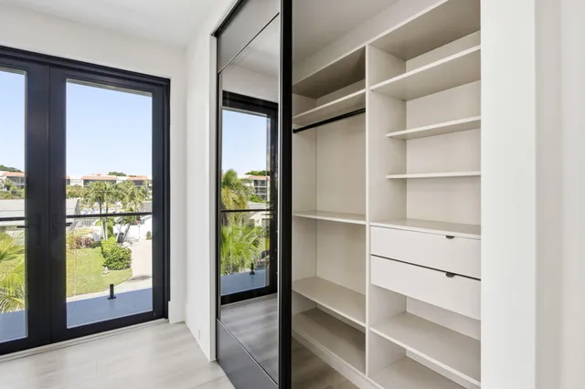 a front view of a house with a yard and potted plants