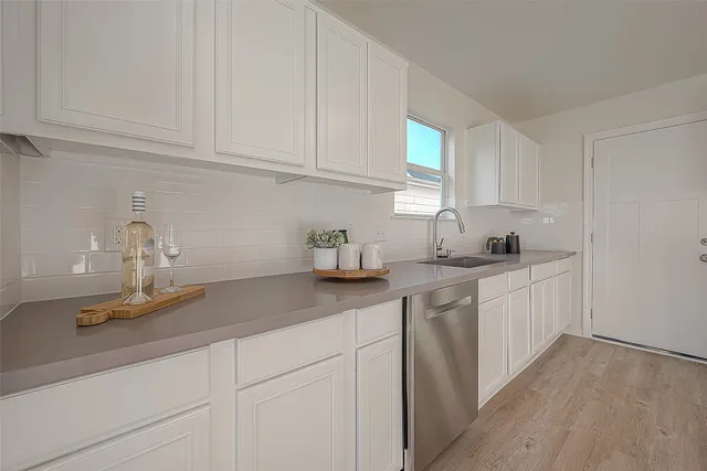a kitchen with granite countertop white cabinets and white appliances