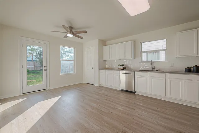 a view of cabinets a sink and dishwasher with wooden floor