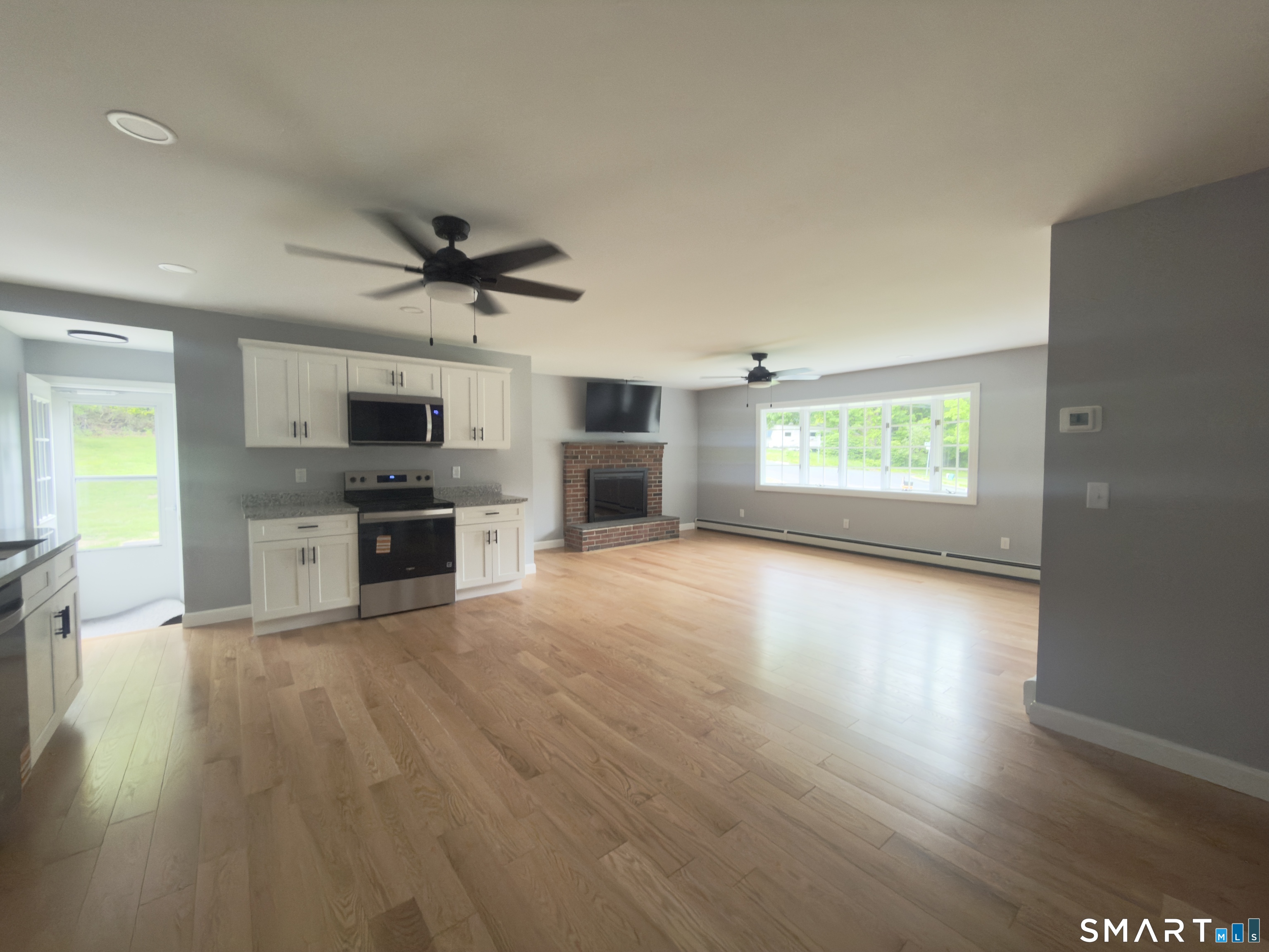 44 Polly Avenue Killingly, CT 06239 - Photo 8 of 22 a view of kitchen with microwave a stove and wooden floor