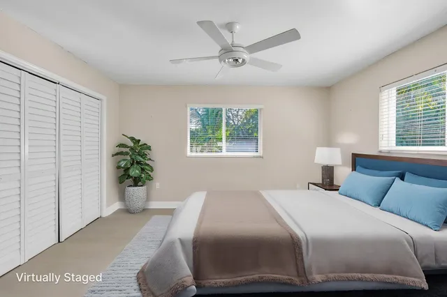 a bedroom with a large bed and a potted plant
