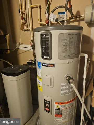 a living room with a table and a refrigerator