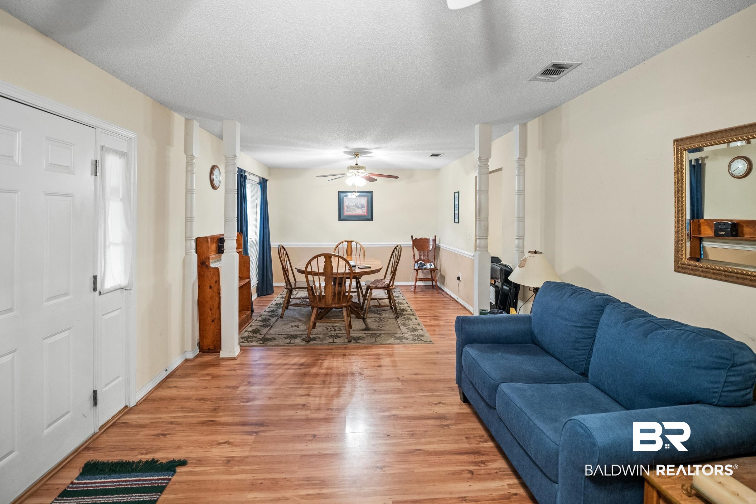 161 Robbins Boulevard Daphne, AL 36526 - Photo 10 of 23 Living area featuring a textured ceiling, visible vents, light wood finished floors, baseboards, and a ceiling fan