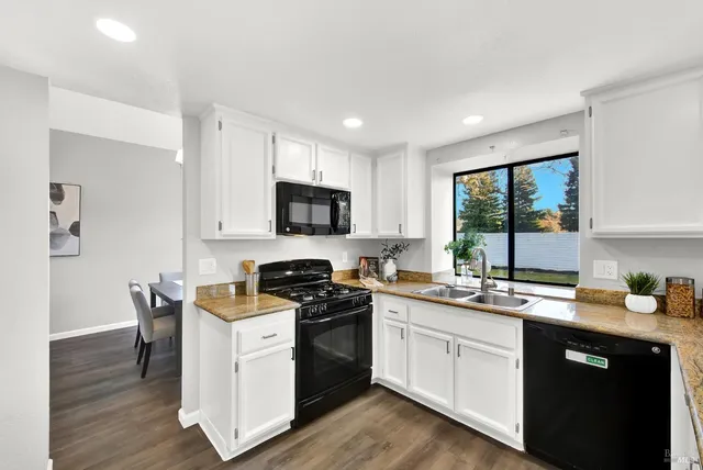 a kitchen with a sink a stove a microwave and wooden floor