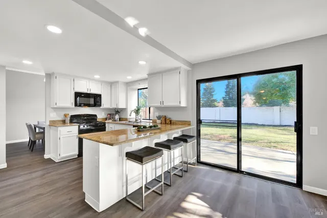 a kitchen with stainless steel appliances granite countertop a stove top oven a sink and a refrigerator