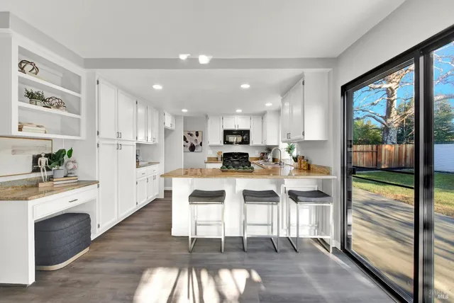 a kitchen with stainless steel appliances kitchen island granite countertop a stove top oven a sink and a refrigerator