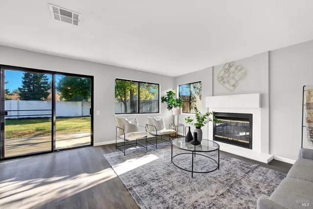 a living room with furniture floor to ceiling window and wooden floor