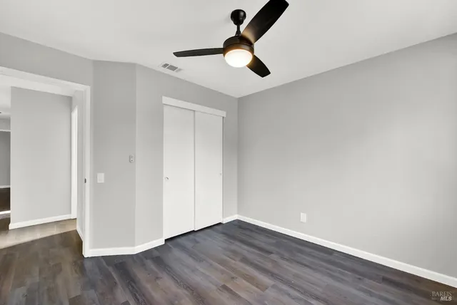 a view of room with hardwood floor and ceiling fan
