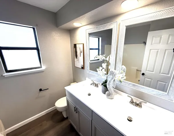 a bathroom with a sink mirror and a toilet