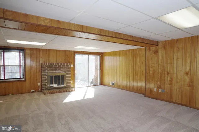 a view of an empty room with a fireplace and a window
