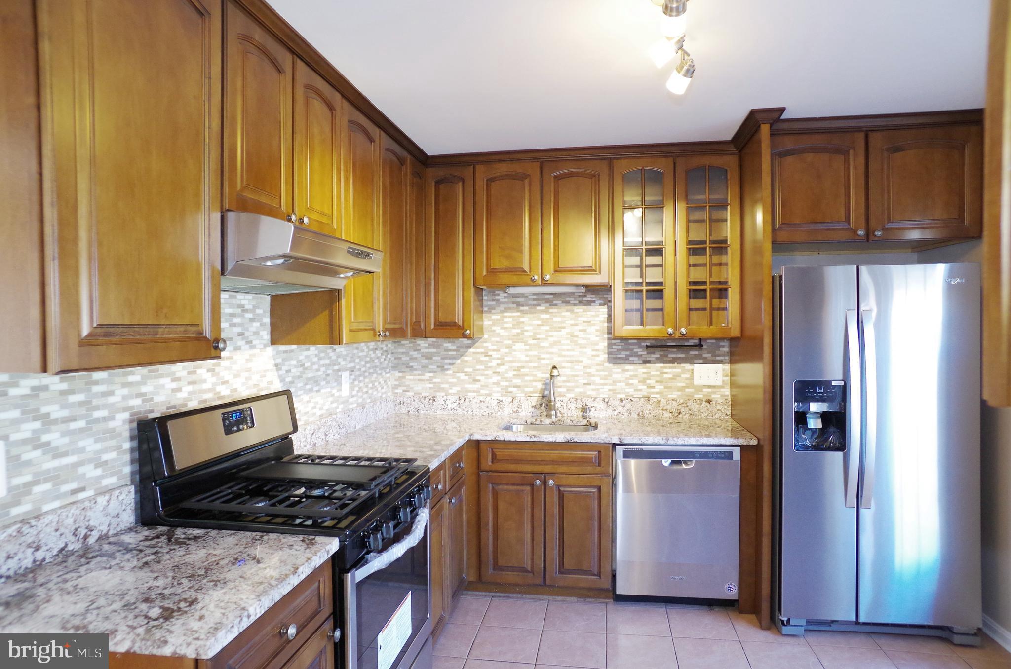 4492 Ruggles Court Annandale, VA 22003 - Photo 7 of 17 a kitchen with stainless steel appliances granite countertop a stove a sink and a refrigerator
