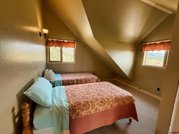 a bedroom with two beds and a window