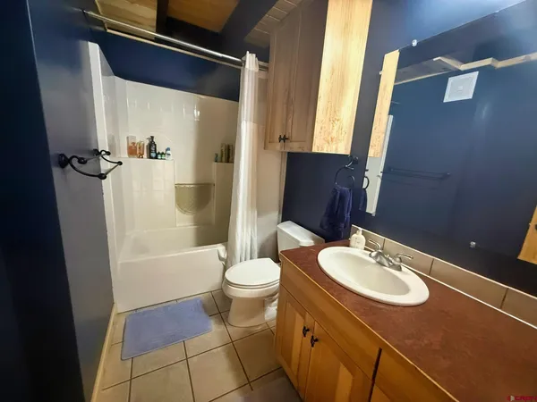 a bathroom with a sink a toilet a mirror and shower