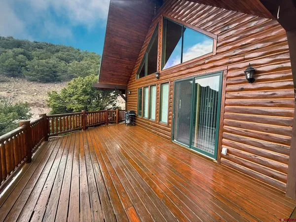 a view of a balcony with wooden floor and fence