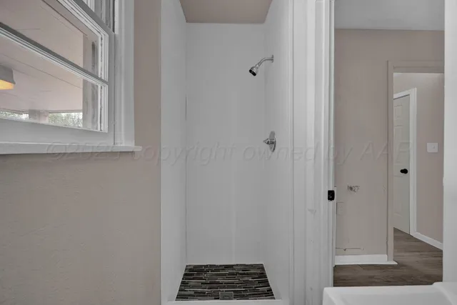 a bedroom with a bed wooden floor and window