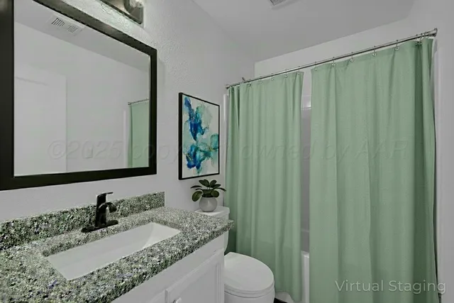 a bathroom with a granite countertop sink toilet and bathtub