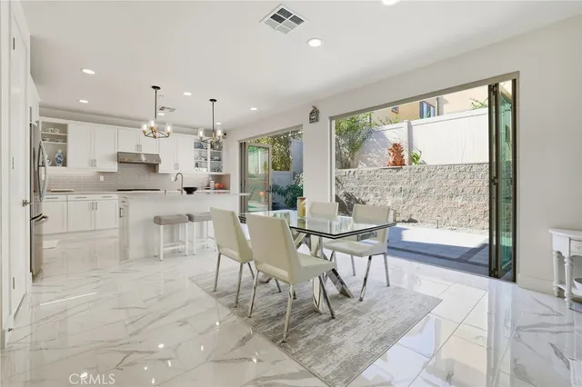a dining area with granite countertop a table chairs and a view of kitchen