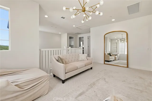 a spacious bedroom with a bed and a chandelier