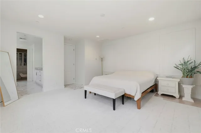 a spacious bedroom with a bed and a potted plant