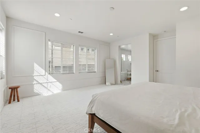 a spacious bedroom with a large bed and a large window