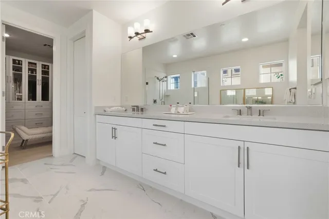 a bathroom with double vanity sinks a vanity a mirror and a shower