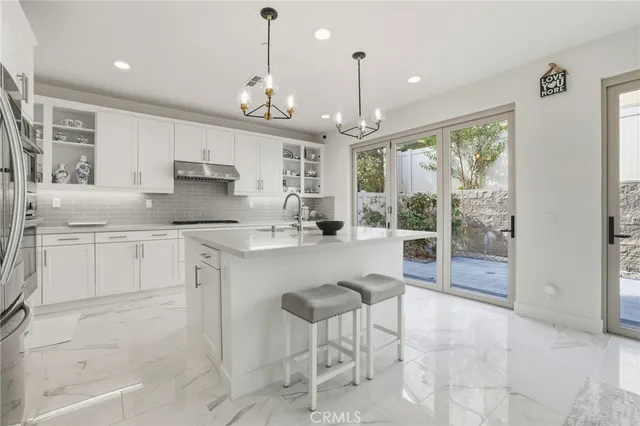 a kitchen with kitchen island granite countertop a counter space a sink appliances and cabinets