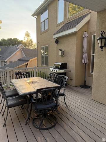 2388 East 850 South Springville, UT 84663 - Photo 11 of 24 Elevated composite deck with dining and entertaining zones, featuring a gas grill, black metal furnishings with cushioned seating, and integrated outdoor lighting