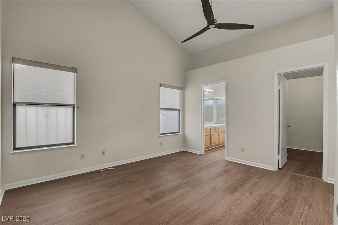 7951 Aspendale Drive Las Vegas, NV 89123 - Photo 20 of 42 Unfurnished bedroom featuring wood finished floors, a ceiling fan, high vaulted ceiling, ensuite bath, and a walk in closet