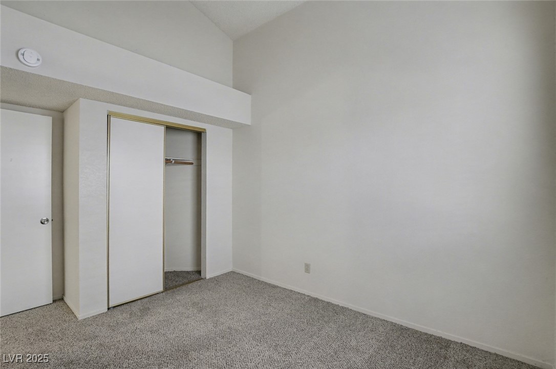 7951 Aspendale Drive Las Vegas, NV 89123 - Photo 30 of 42 Unfurnished bedroom with light carpet, vaulted ceiling, and a closet