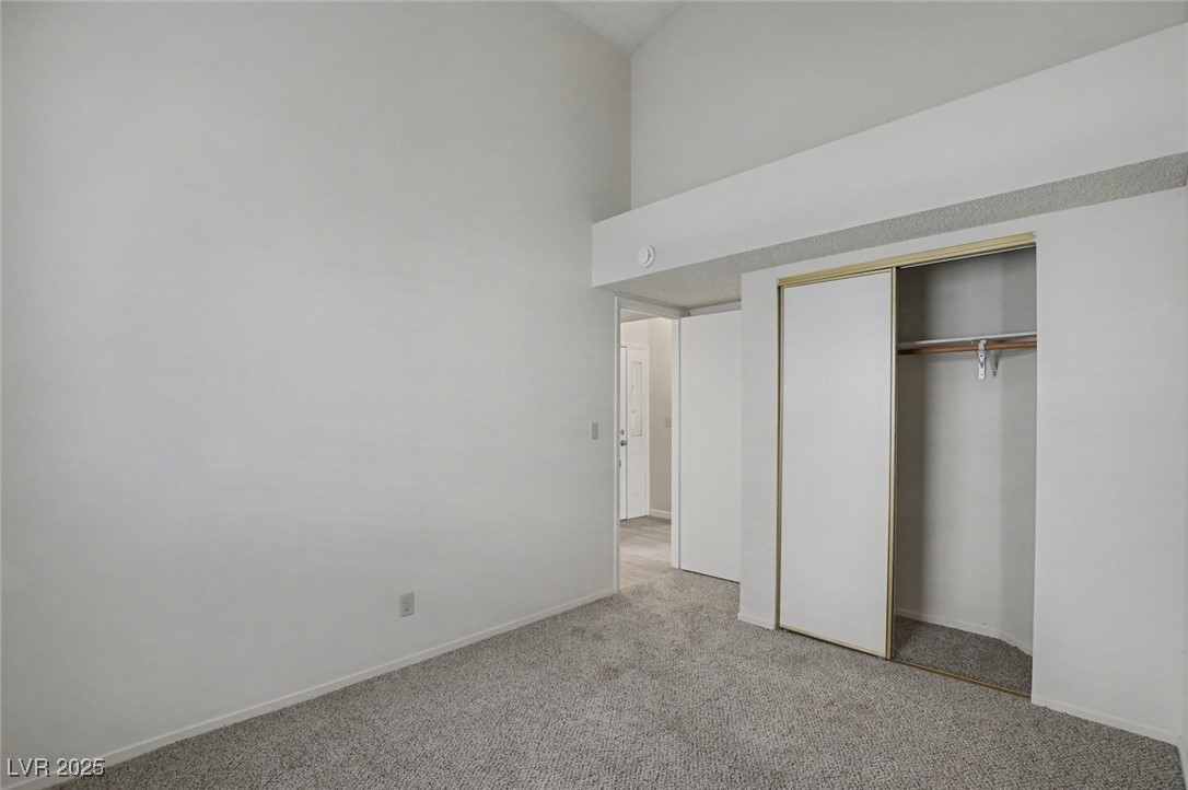 7951 Aspendale Drive Las Vegas, NV 89123 - Photo 31 of 42 Unfurnished bedroom featuring light carpet, a towering ceiling, and a closet