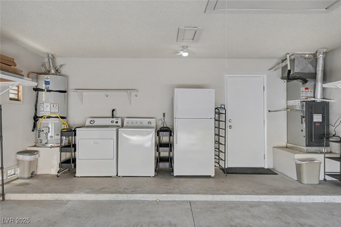 7951 Aspendale Drive Las Vegas, NV 89123 - Photo 33 of 42 Garage with freestanding refrigerator, water heater, heating unit, and separate washer and dryer
