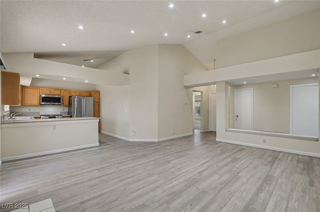7951 Aspendale Drive Las Vegas, NV 89123 - Photo 8 of 42 Unfurnished living room with light wood-style flooring, recessed lighting, and high vaulted ceiling
