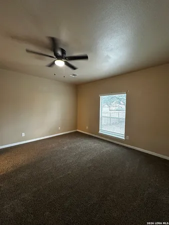 an empty room with a ceiling fan and a window
