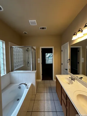 a bathroom with a tub sink and mirror