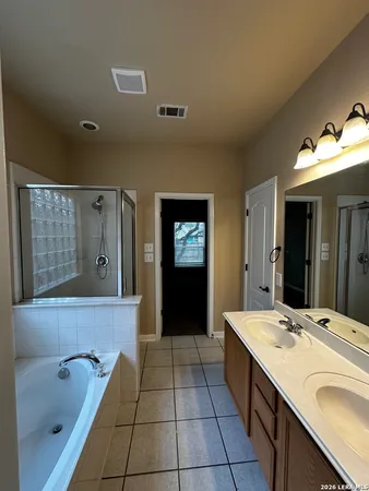 a bathroom with a tub sink and mirror