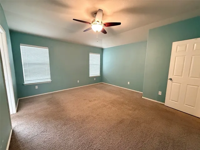 a view of a livingroom with a ceiling fan and kitchen view