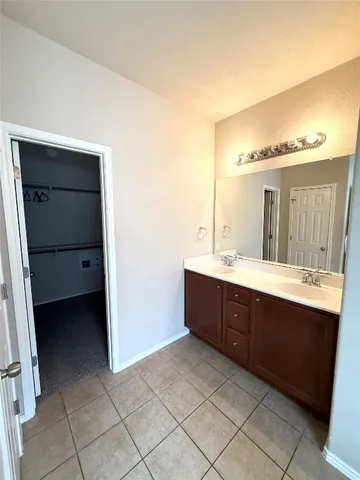 a spacious bathroom with a double vanity sink and mirror
