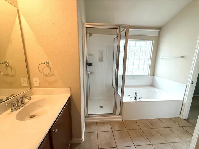 a bathroom with a tub a sink and a mirror