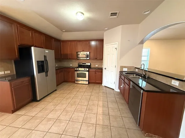 a kitchen with stainless steel appliances granite countertop a refrigerator and a stove