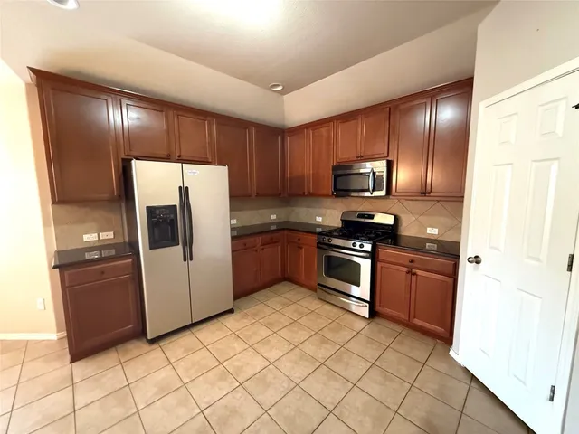a kitchen with granite countertop stainless steel appliances and white cabinets