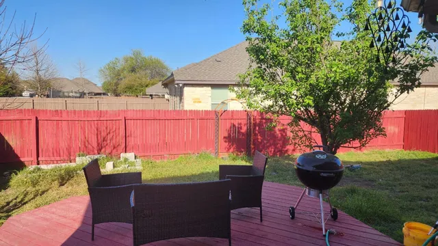 a view of a chairs and table in the backyard