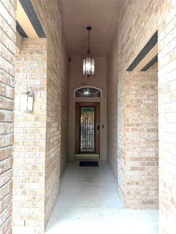 a view of a livingroom with a chandelier curtains and large windows