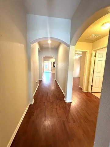 a view of a hallway with wooden floor
