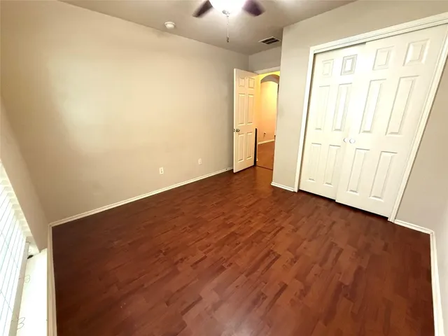 an empty room with wooden floor and sliding door