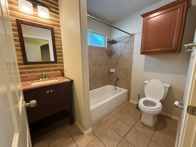 a bathroom with a toilet a sink tub and mirror